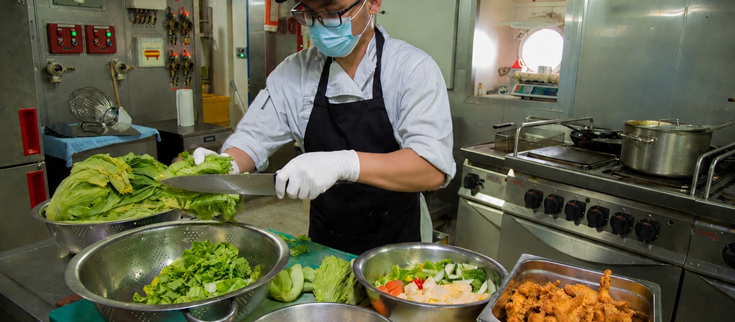 Catering staff plating meals in a commercial kitchen